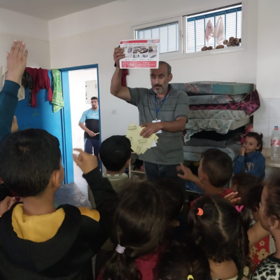 Séance d'éducation aux risques par des volontaires de HI dans un camp des Nations unies, à Khan Younis, à Gaza.
