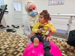 Noor, 3 ans, a été grièvement blessée pendant le séisme du 6 février 2023. Après sept mois d’hospitalisation, elle continue à être suivie régulièrement par les équipes de l’hôpital Aqrabat, partenaire de HI dans le Nord-Ouest de la Syrie. En photo ici avec sa kinésithérapeute.  