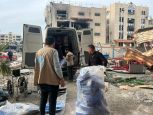 Un camion au milieux des ruines avec trois personnes de HI qui sorte la marchandise à Gaza. 