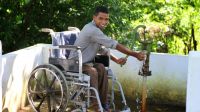 Dinesh Rana, 22 ans, est le président du comité de gestion des catastrophes de Shankarpur (DMC), essayant un fauteuil roulant pour accéder à une pompe à eau surélevée