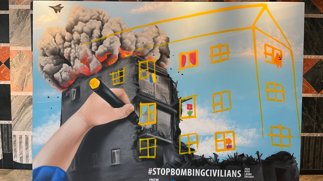 Vor dem Konferenzsaal gestalteten drei ukrainische und deutsche Künstler:innen gemeinsam ein Graffiti mit dem Slogan unserer Kampagne «Stop Bombing Civilians». Es zeigt ein zerstörtes Haus in der Ukraine und den Arm eines Kindes, das Bilder malt, die neues Leben und Hoffnung symbolisieren.