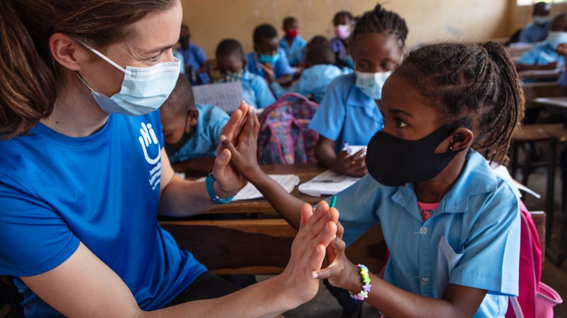 Une femme avec un t-shirt HI avec une petite fille dans une salle de classe.