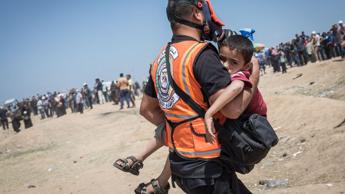 Ein Arzt bringt ein Kind in einen Krankenwagen, nachdem er am 14. Mai 2018 Tränengas in Gaza-Stadt, Gaza, eingeatmet hat.