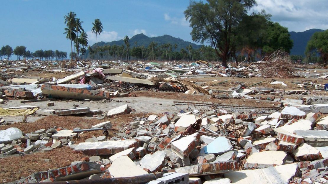 Des hommes recherchent toujours un membre de leur famille dans leur maison endommagée au village de Balaroa à Palu le 1er octobre 2018, suite au tremblement de terre et au tsunami qui ont frappé la région le 28 septembre.