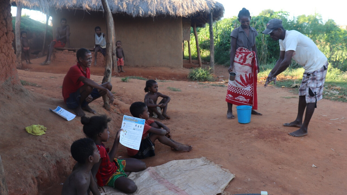 Marcelin, formé par HI, apprend à une famille les gestes d'hygiène pour se protéger du virus.