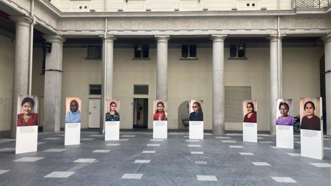 Foto von 8 nepalesischen Frauen, die in einem Bogen in einem Innenhof eines Gebäudes positioniert sind