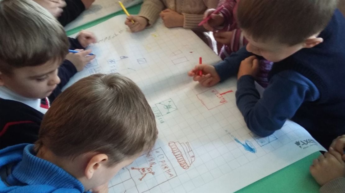 Kinder, die während einer Minenaufklärungsschulung gefährliche Situationen nachzeichnen