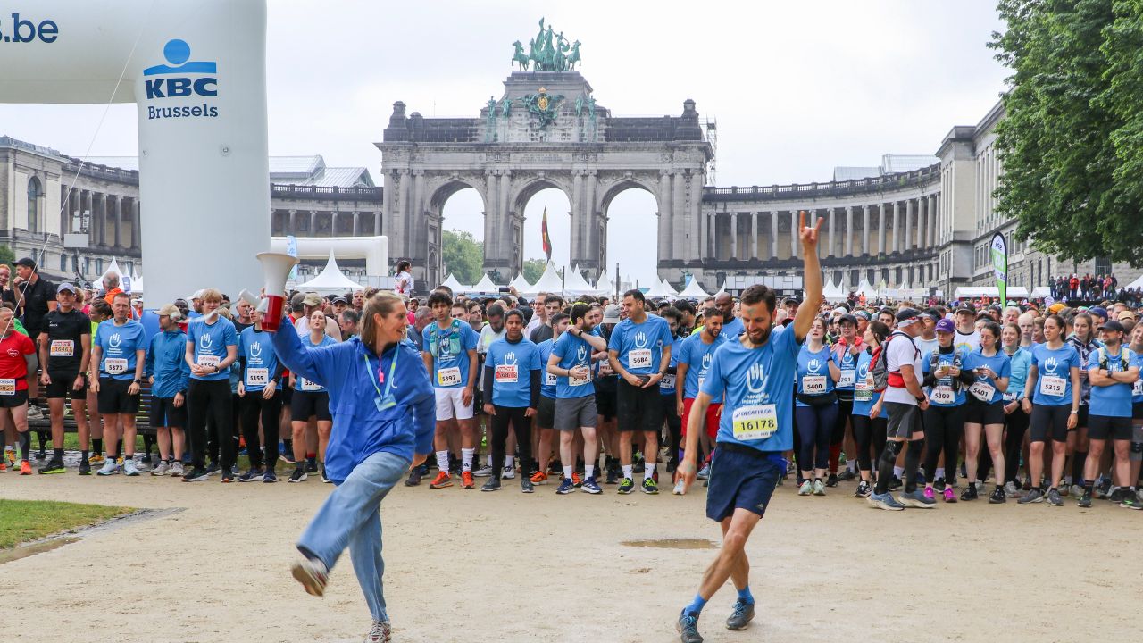 Personnes portant un t-shirt Handicap International devant l'arrivée des 20km de Bruxelles 