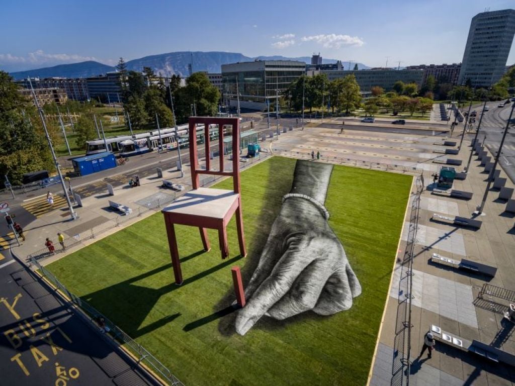 Schwarz-Weiß-Fresko einer Hand, die sich in Broken Chair einem vierten Fuß nähert.