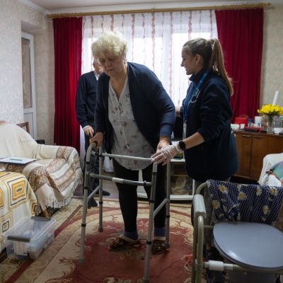 Distribution de kits d'hygiène par un membre HI avec à côté de lui un bénéficiaire en fauteuil roulant