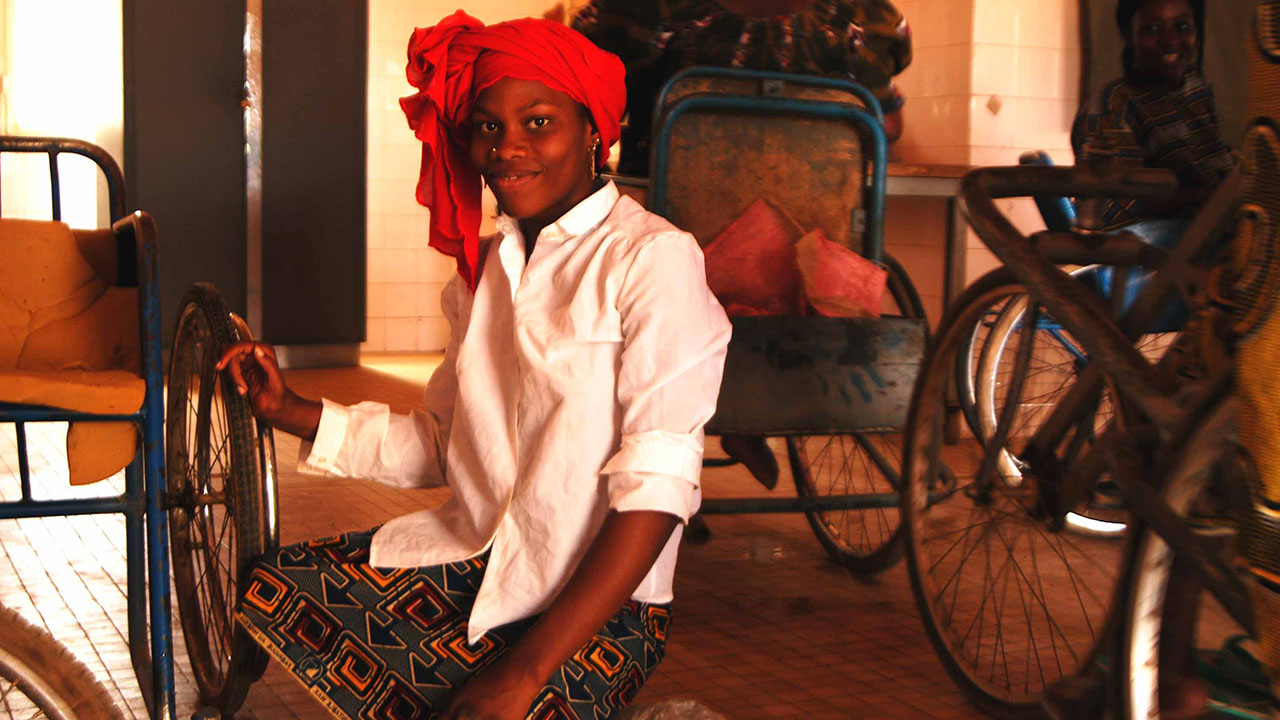 Femme ayant reçu un fauteuil roulant de HI