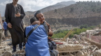 Une femme est assise sur les décombres de bâtiments détruits, à la suite du tremblement de terre dans le village d'Imi N'Tala, près d'Amizmiz.