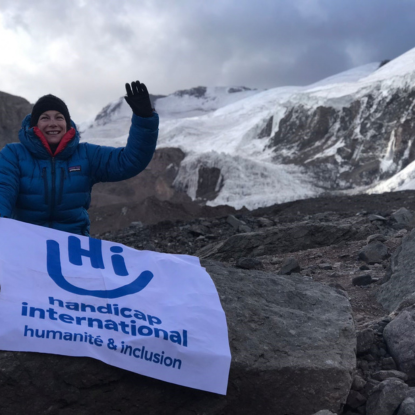 Veronique beim Aufstieg zum Aconcagua. Sitzend neben der HI-Fahne: