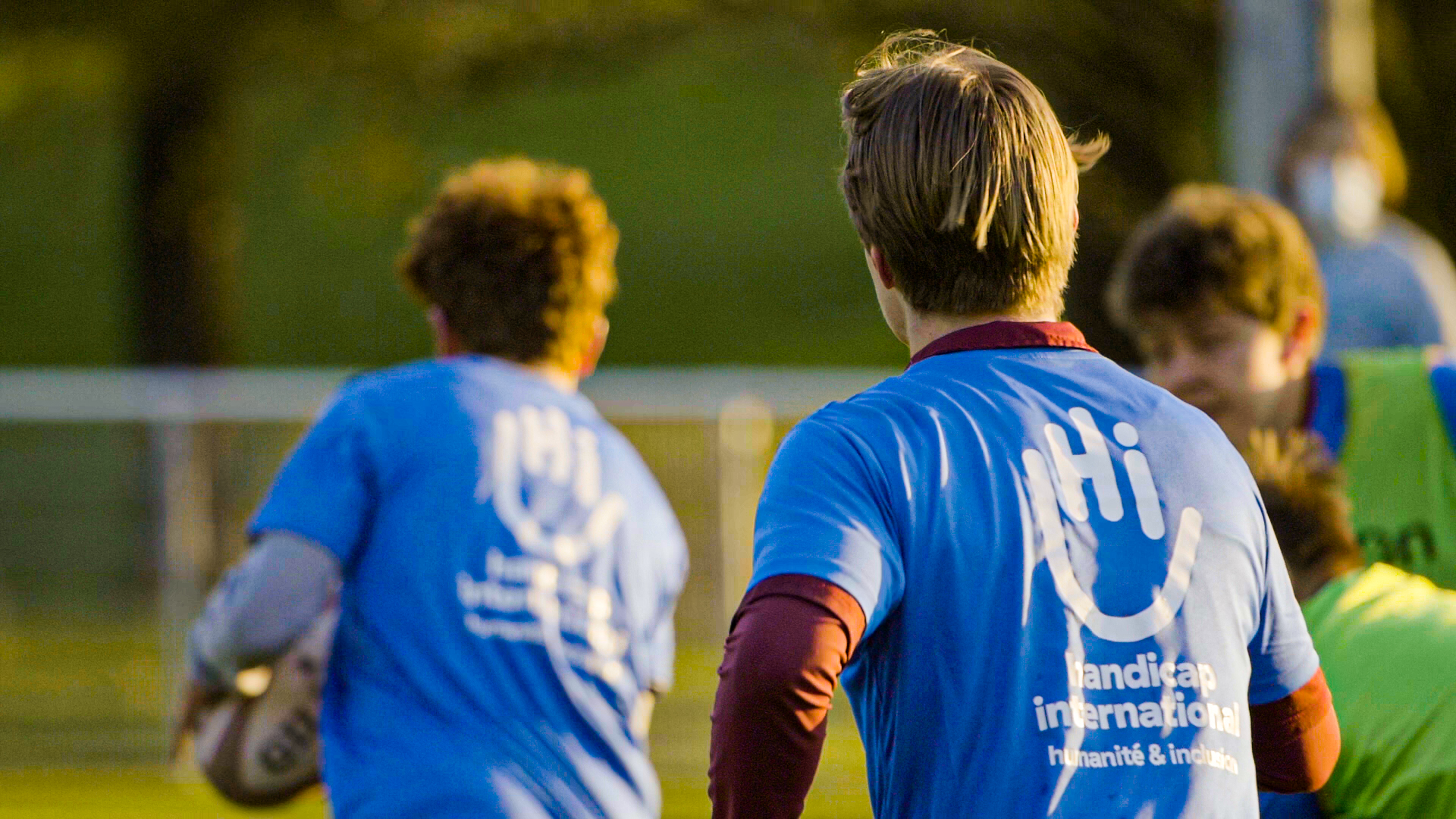 Rugbyspieler von hinten mit einem blauen HI-T-Shirt.