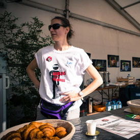 Bénévole pour Handicap International devant un stand vendant des croissants.